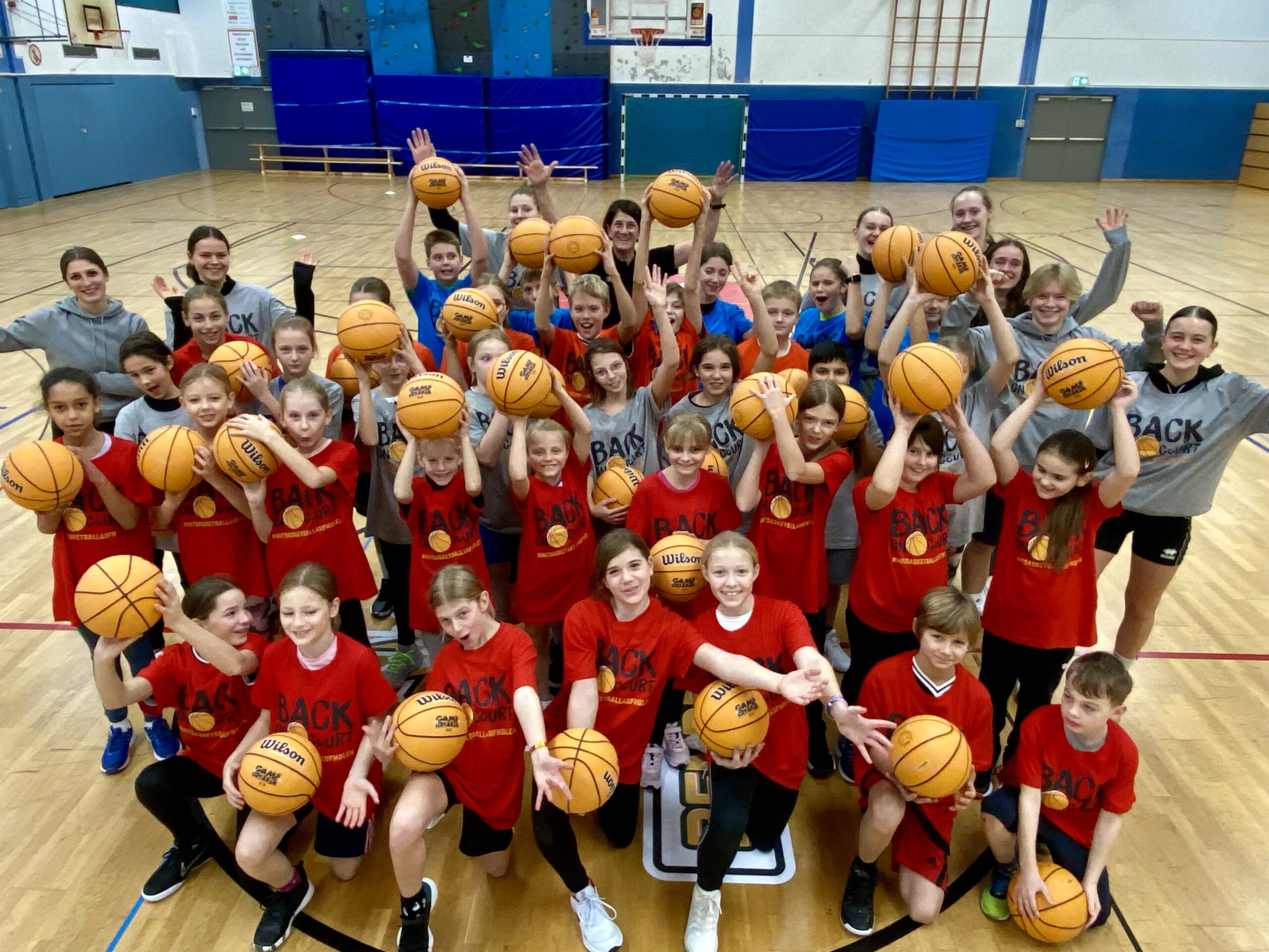 Gruppenbild Kinder und Trainer*innen mit Basketbällen