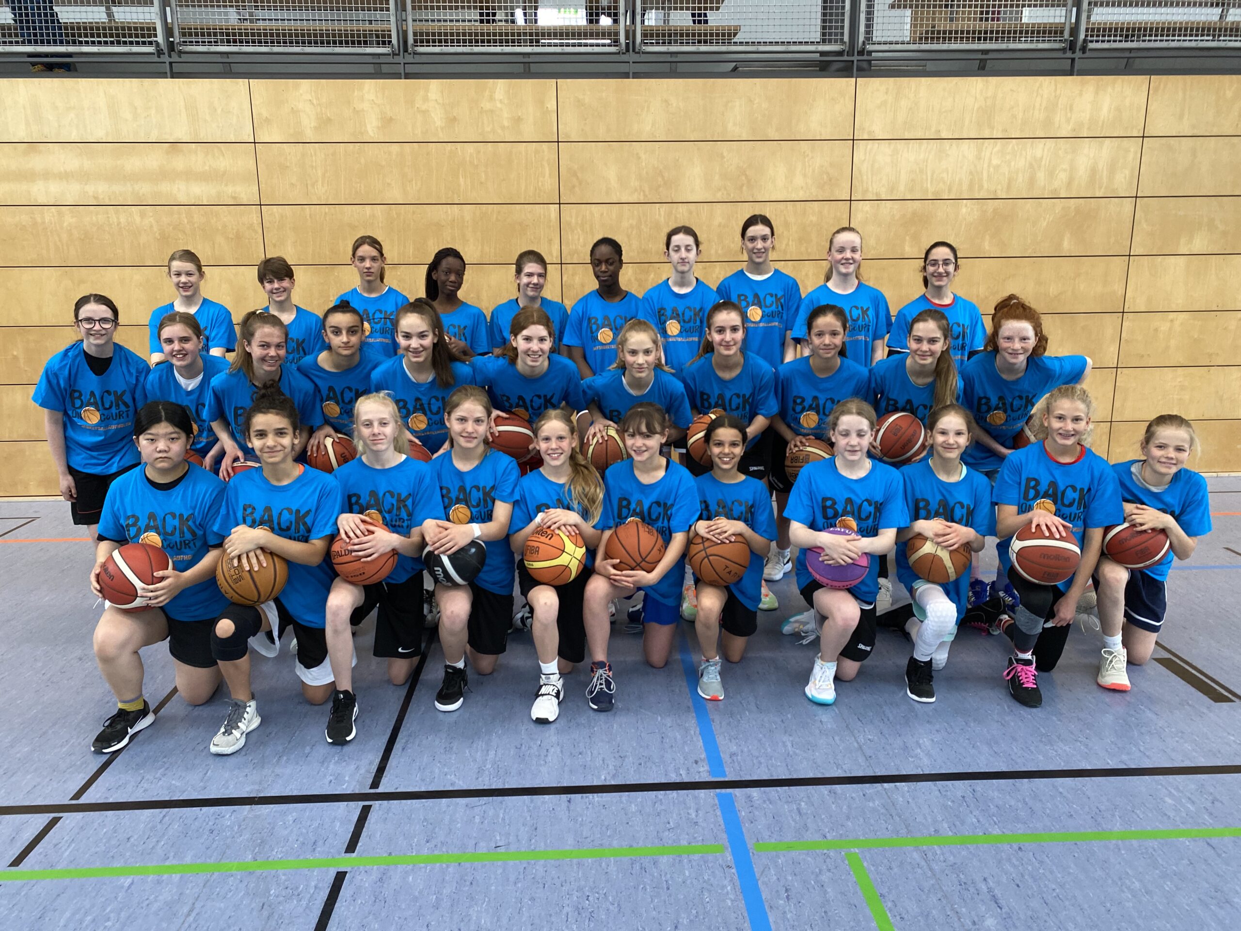 Gruppenbild Mädchen mit Basketbällen und blauen TShirts