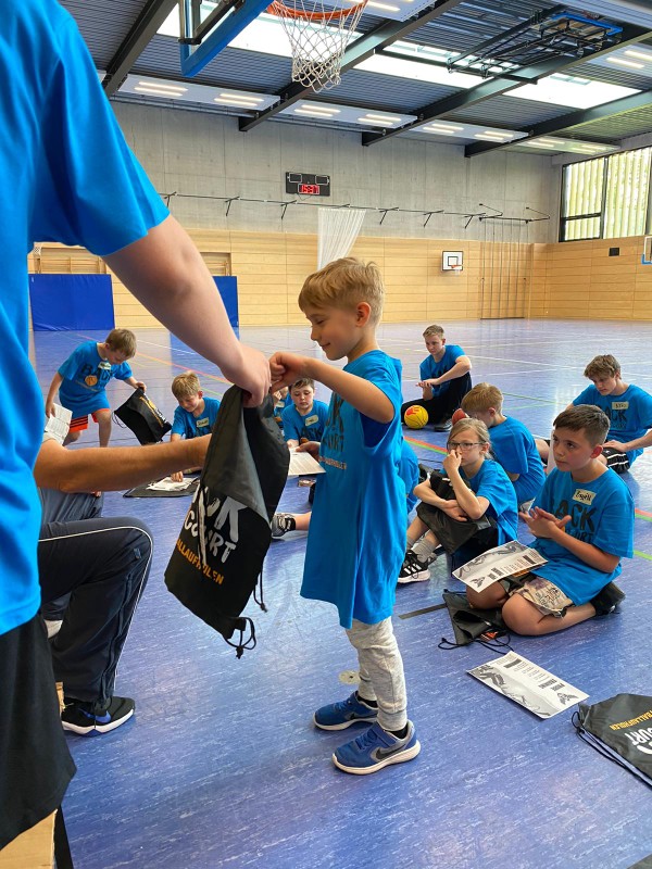 Ausgabe der Turnbeutel an Kinder