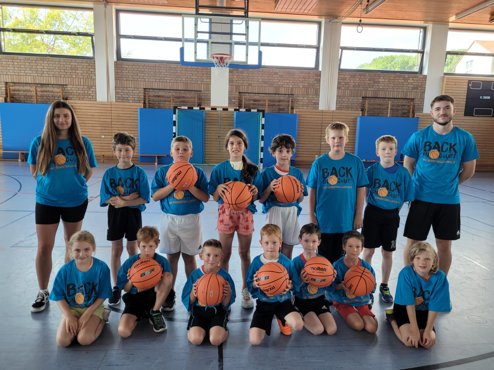 Gruppenbild Teilnehmende in back on court TShirts