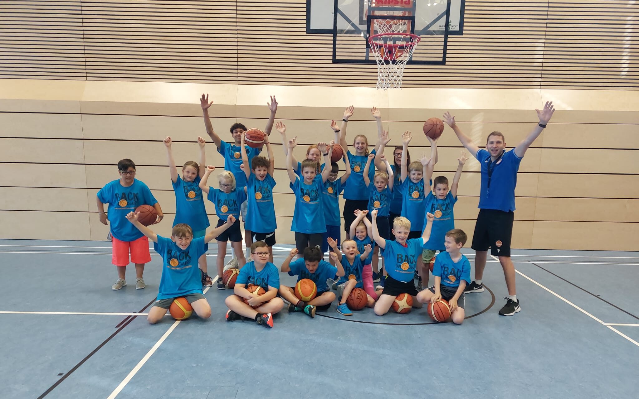 Gruppenbild jubelnde Teilnehmende mit Basketbällen