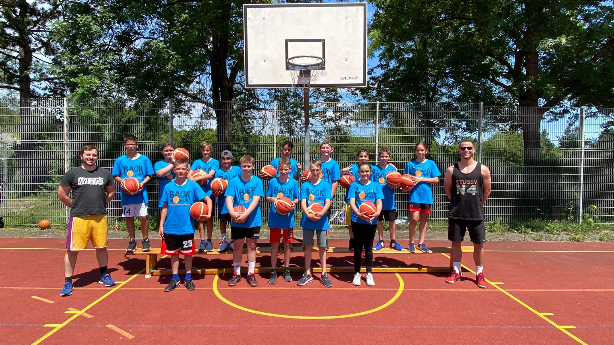 Gruppenbild Teilnehmende im Freien unter einem Korb