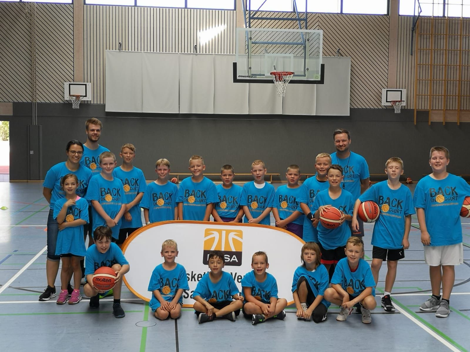 Gruppenbild Kinder und Trainer*innen mit Basketbällen