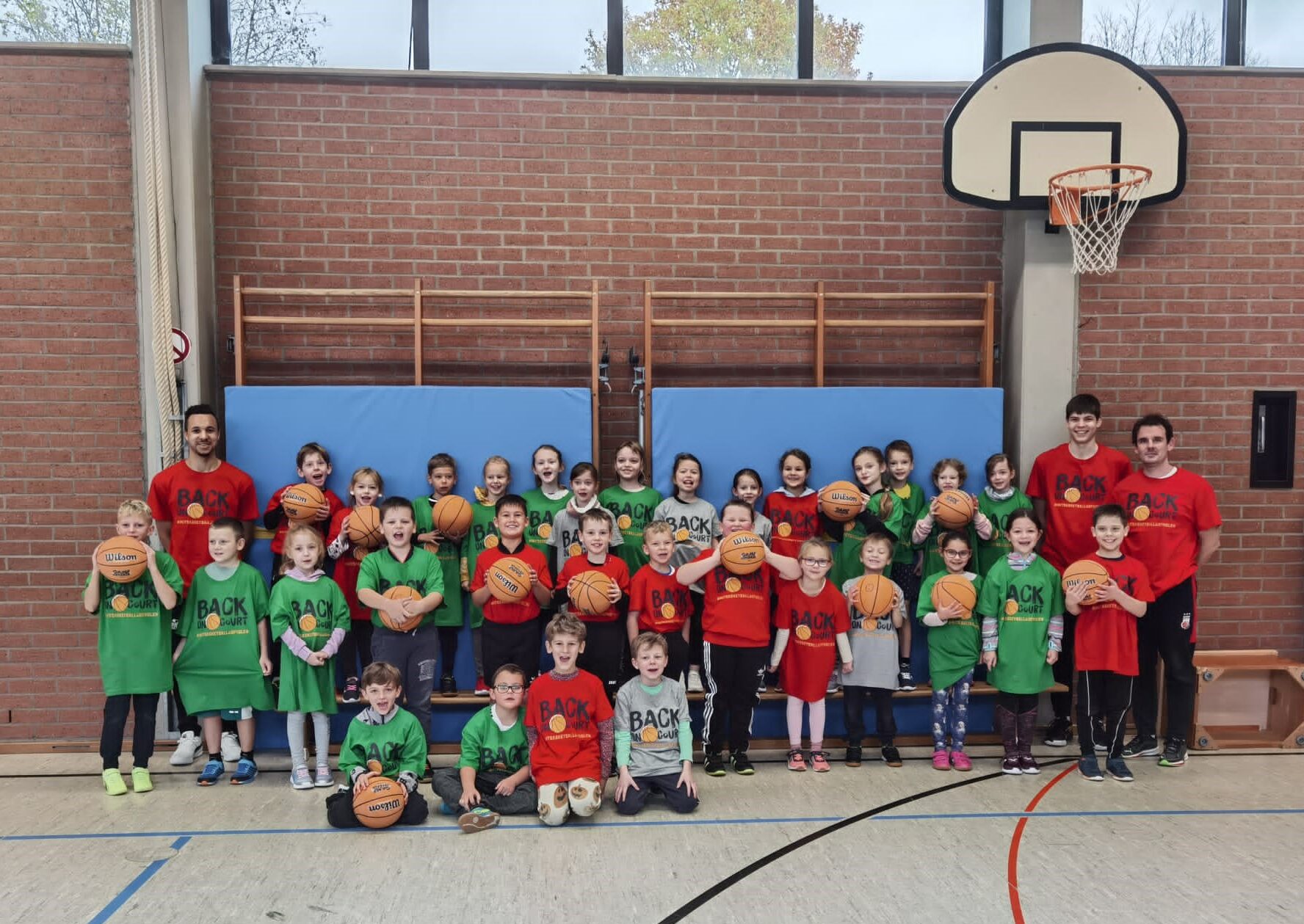 Gruppenbild Kinder und Trainer*innen mit Basketbällen