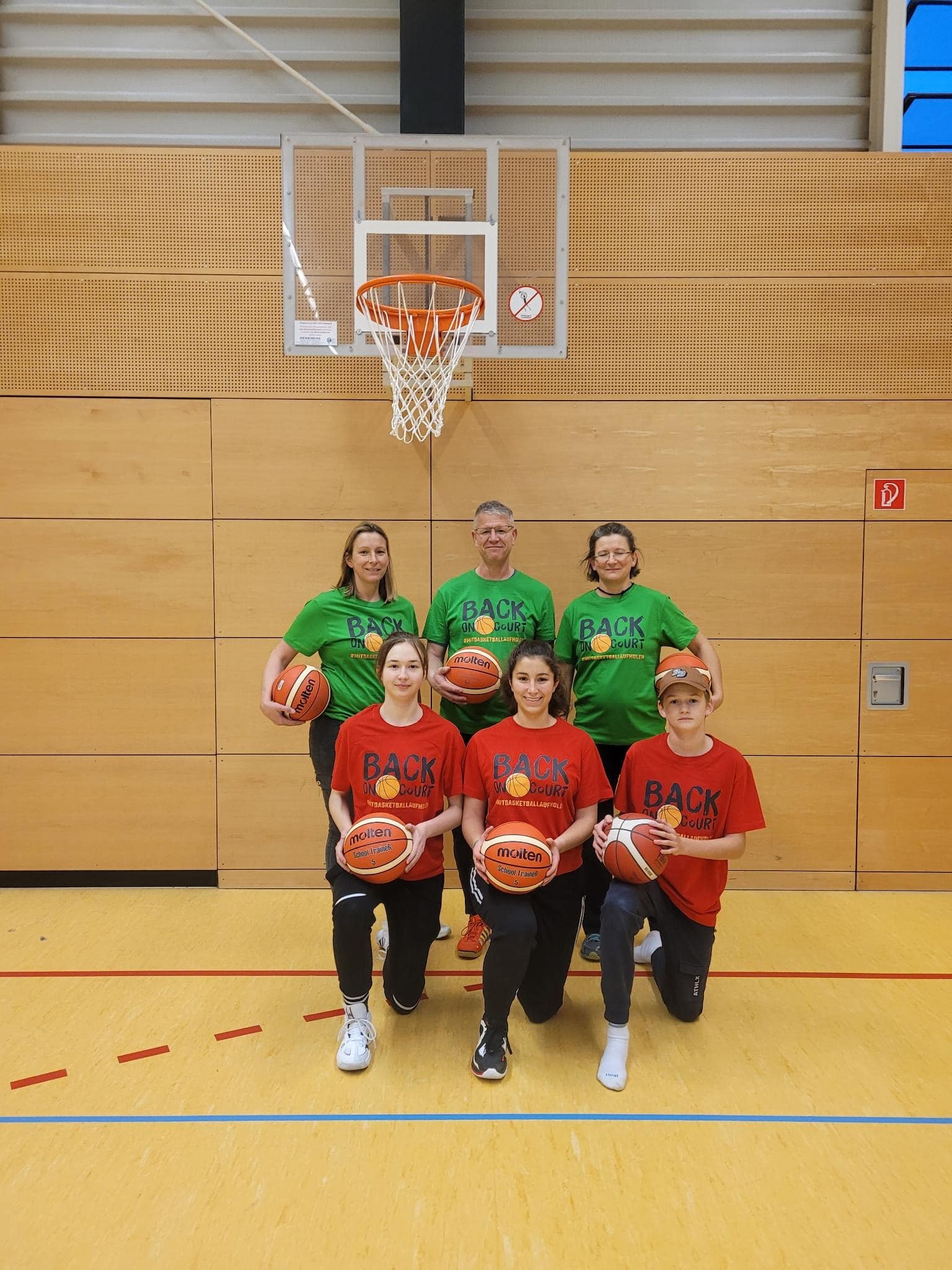 Gruppenbild Trainer*innen mit Basketbällen