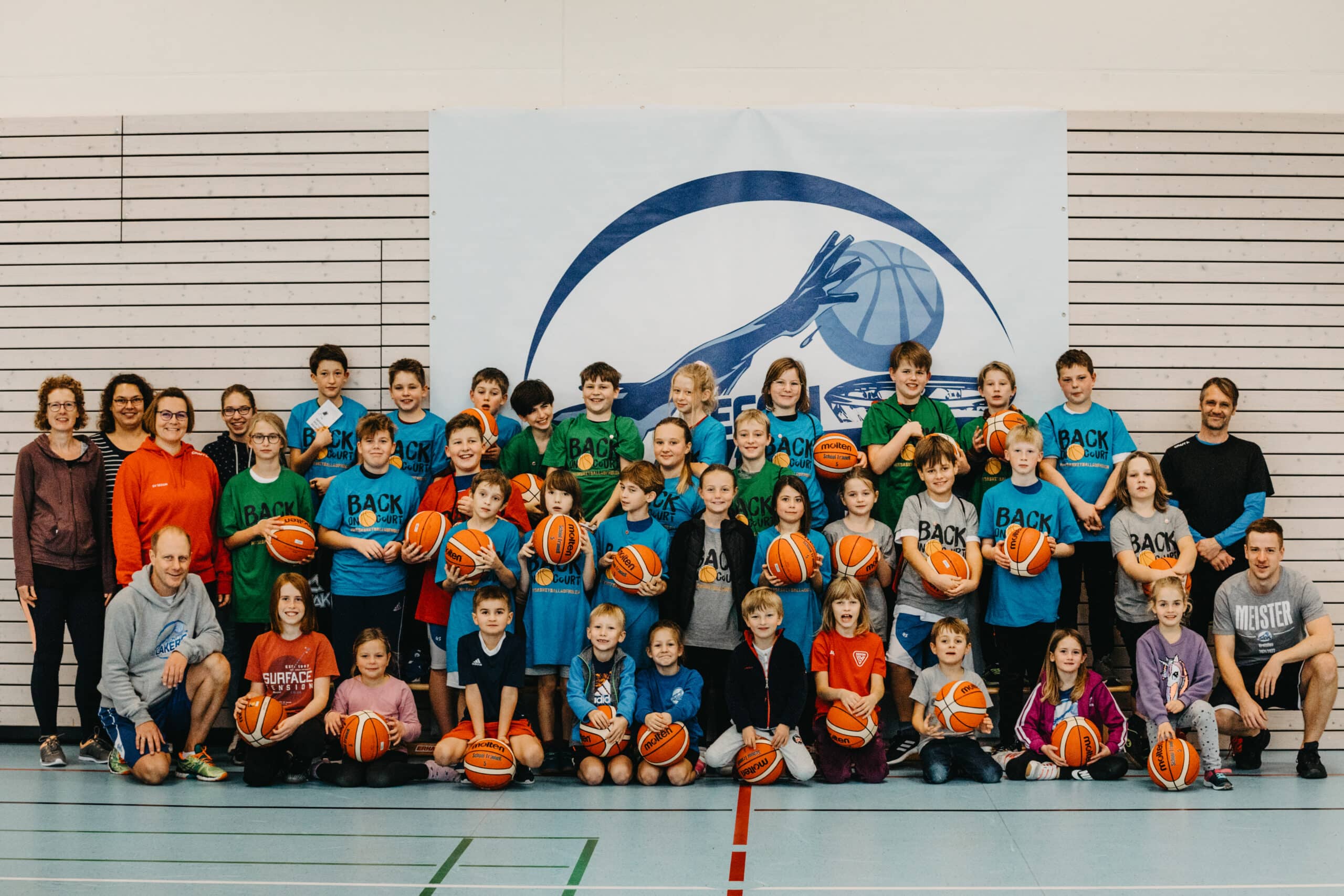 Gruppenbild Kinder und Trainer*innen mit Basketbällen