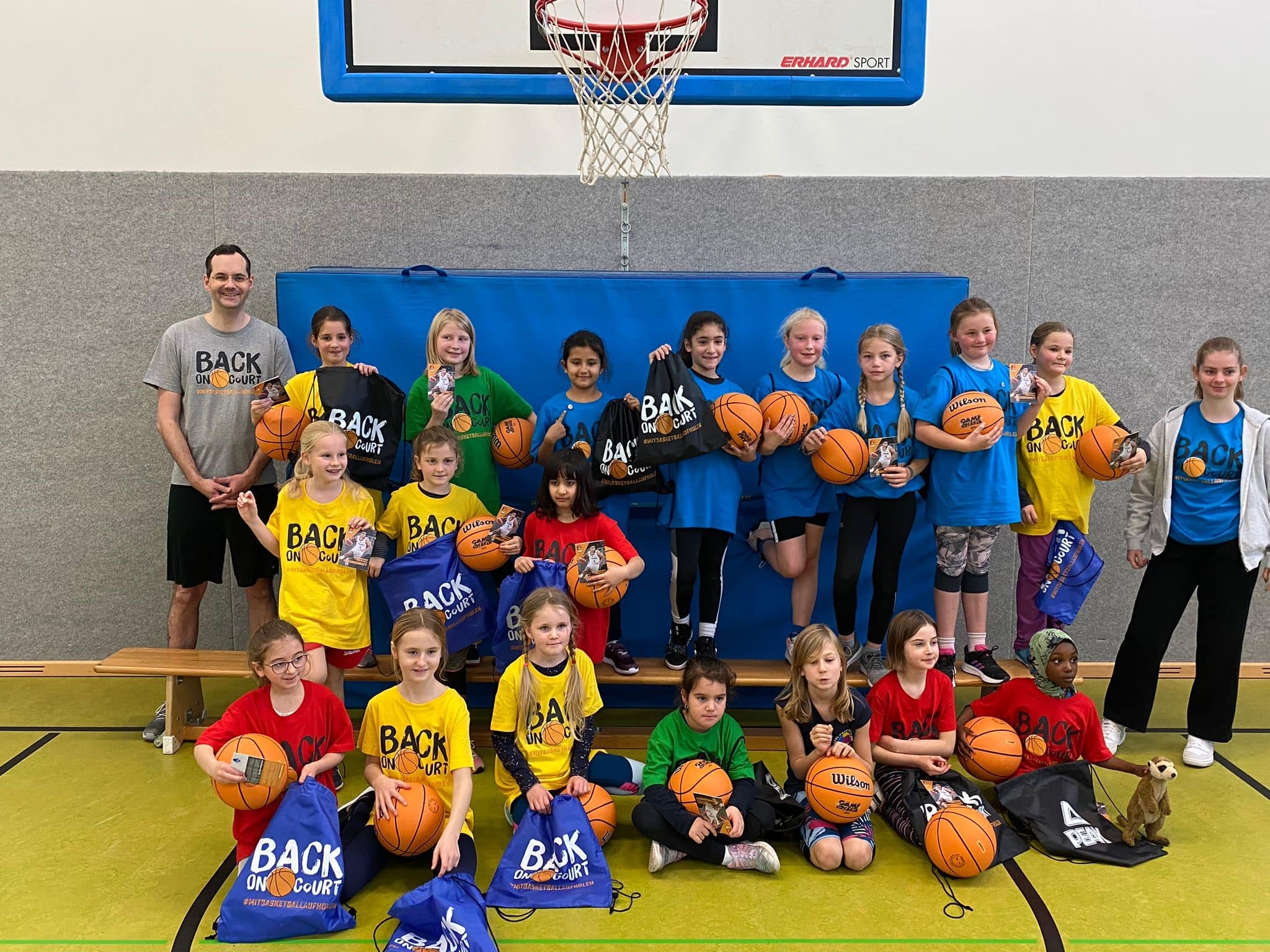 Gruppenbild Mädchen und Trainer*innen mit Basketbällen und Gymbags