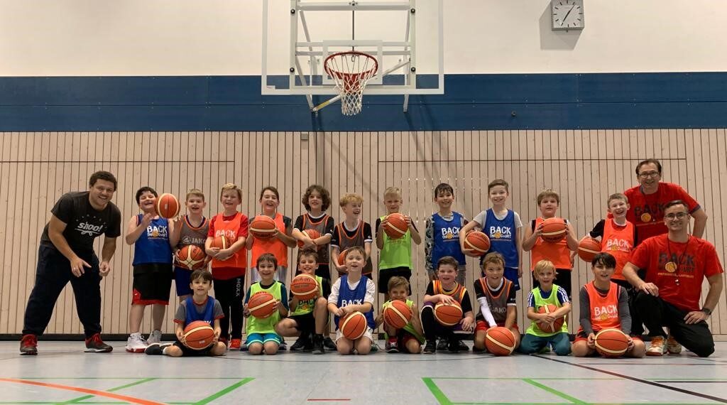 Gruppenbild Kinder und Trainer mit Basketbällen