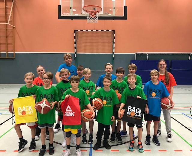 Gruppenbild Kinder und Trainer*innen mit Basketbällen und Gymbags